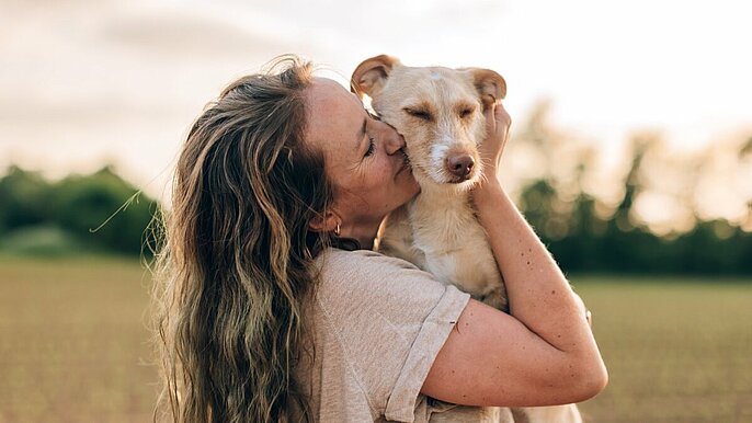 close up portrait of a happy woman hugging and kissing her dog -  psie targi lodz pasaż łódzki
